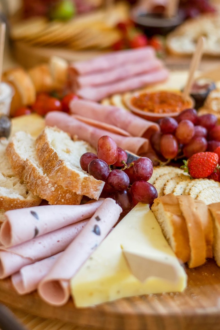 Charcuterie Board of Soft Cheeses, Berries, Cold Cuts, Sliced Bread and Hummus Recipe