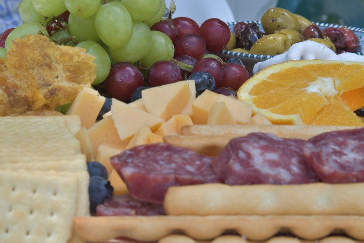 Charcuterie Recipe - Ham, Camembert, Orange Wedges, Green and Red Grapes with Olives Charcuterie